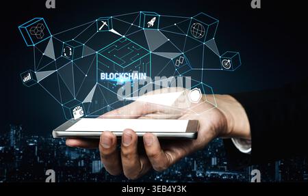 Hand Holding Smartphone with Digital Blockchain Interface and Technology Icons Representing Innovation and Connectivity in Modern Business Landscape Stock Photo