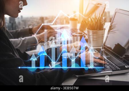 Business professionals collaborate in a modern office, utilizing laptops to analyze financial data, showcasing growth trends through dynamic charts Stock Photo