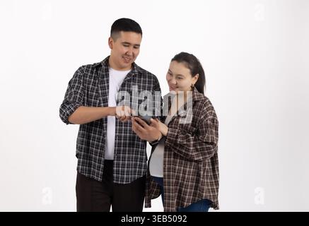 Man and woman looking at a smartphone screen together Stock Photo