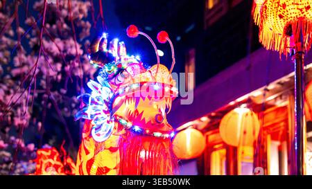 View of an illuminated Chinese dragon head with colorful LED lights and traditional lanterns at night during a festival at the Lan Su Chinese Garden i Stock Photo