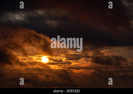 View of a dramatic sunset with golden light breaking through dark, heavy storm clouds over Kyiv, Kyiv city, Ukraine. Stock Photo