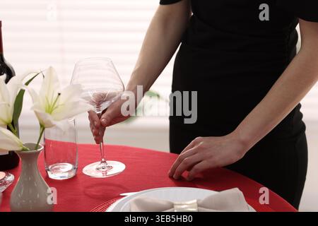 Woman setting table for dinner at home, closeup Stock Photo
