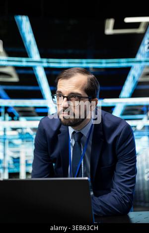 Upgrading equipment, laptop and engineer in data center with database storage. Updating cloud computing rigs, notebook device and software developer in server farm, technology systems concept Stock Photo
