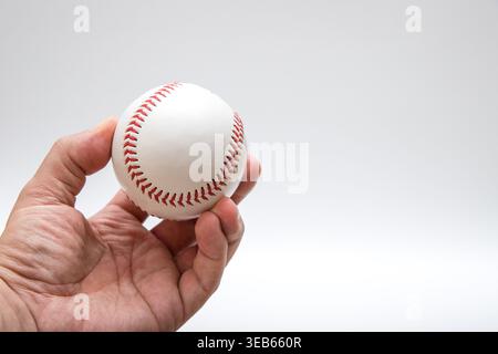 Hand holding baseball ball isolated on light background Stock Photo