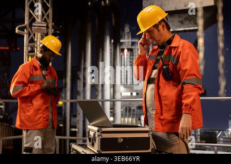 Pensive focused environmental officer on offshore drilling platform writing carbon footprint data on a clipboard, ensuring compliance and efficient petroleum extraction from the ocean. Stock Photo