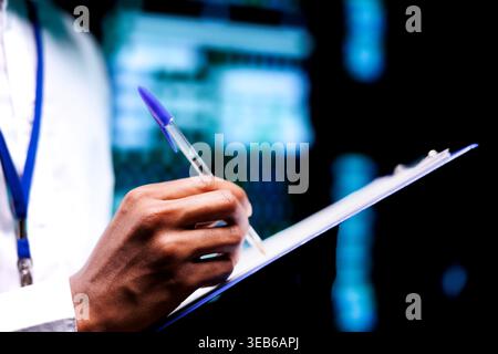 Technician performing diagnostic assessments on server rigs to detect problems with data center devices. Repairman diligently reviewing maintenance list examining for potential malfunctions Stock Photo