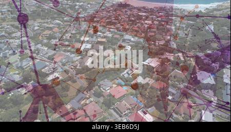 Displaying aerial coastal suburb rooftops and streets, showing pools and digital network overlay Stock Photo