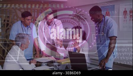 Using doctor wearing white coat and VR headset gesturing at hospital meeting, with laptop holograms Stock Photo