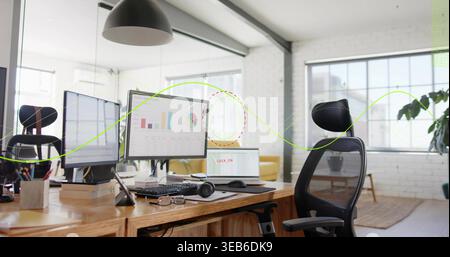 Displaying wooden workstation in open loft office, showing dual monitors, laptop, keyboard Stock Photo