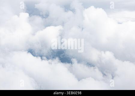 White clouds seen from airplane above the clouds. Stock Photo