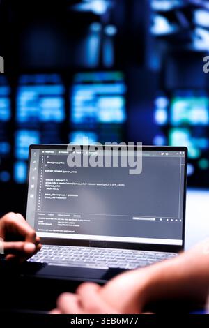 Admin team maintaining and updating server rigs, writing lines of code on laptop terminal, close up. Coders using JavaScript, Java, and database programming to ensure seamless data center computing Stock Photo