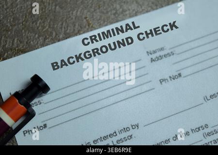 Concept of criminal background check write on application isolated on Wooden Table. Stock Photo