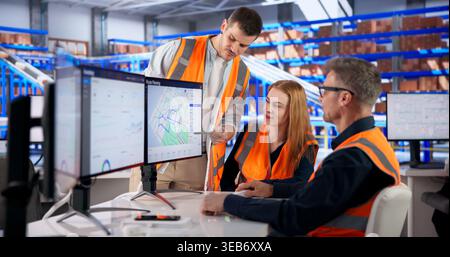 Logistics Coordinator Uses Multiple Screens To Track Delivery Routes Efficiently. Stock Photo