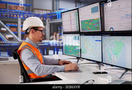 Efficient Logistics Coordinator Operating Desktop In A Bustling Distribution Hub Stock Photo