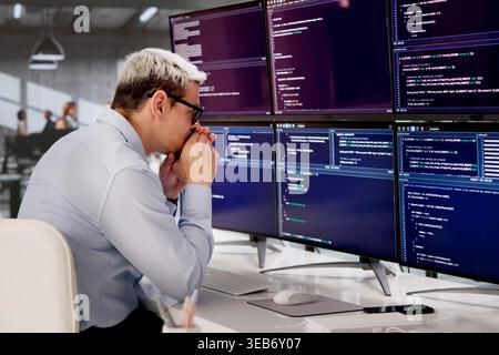 Frustrated Male Developer Struggling With Complex Web Code At Office Desk Stock Photo