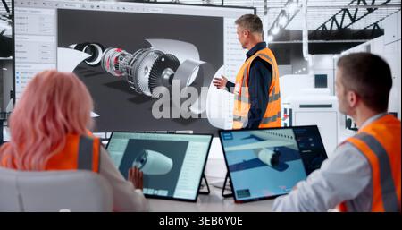 Aerospace Engineer Leads Diverse Team Using CAD Software For Aircraft Design. Stock Photo