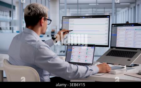 ERP Expert Evaluates Cloud-Based Business Management Software On Laptop For Strategic Planning Stock Photo