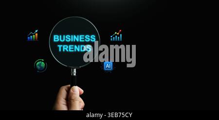 Business trends concept shown through a magnifying glass focusing on global market growth, artificial intelligence integration, and financial data cha Stock Photo
