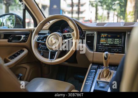 Batumi, georgia 21 april 2026: porsche macan luxury suv interior with beige leather details, steering wheel, and multimedia display. Driving in batumi Stock Photo