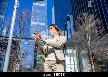Businesswoman using smartphone in manhattan financial district Stock Photo