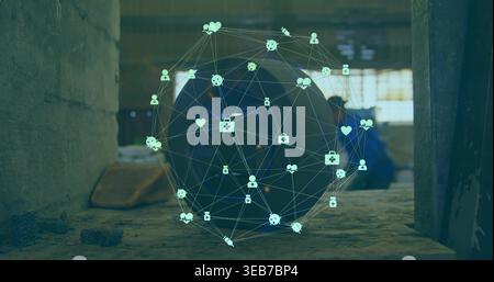 Hovering holographic network sphere projecting icons over tire in workshop, blue-coveralls worker Stock Photo