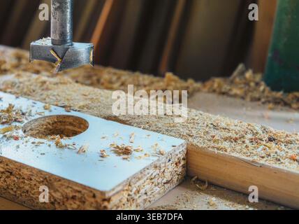 Drilling holes in the particle board with a drill Stock Photo