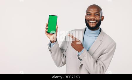 Portrait, businessman and phone with green screen in studio, smile or recommendation for banking app. Black person, marketing and mobile for Stock Photo
