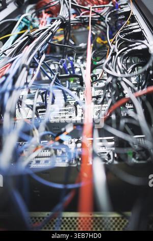 Closeup, rack and power cables in server room for database, IT infrastructure and backup system. Hardware, mainframe and optical panel with electrical Stock Photo