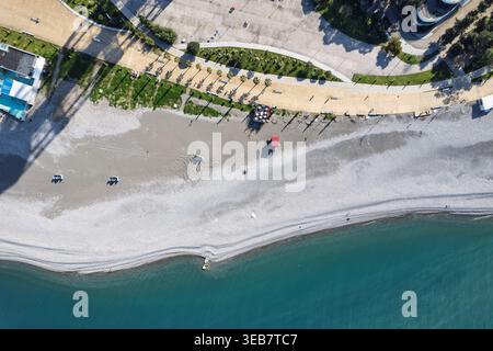 Batumi, georgia 21 april 2026: aerial view of the black sea coastline in batumi, georgia, featuring a pebble beach, promenade, and palm trees during d Stock Photo