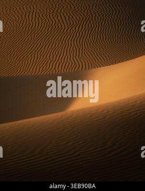 View of rippled sand dunes with golden light and deep shadows in the desert of Balochistan, Pakistan. Stock Photo