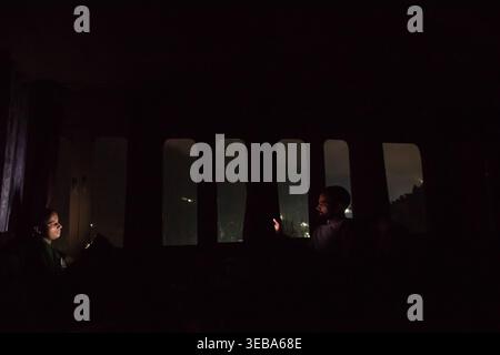 This image shows two individuals using their glowing mobile phones inside a dark vehicle at night, representing themes of technology, connection, and Stock Photo