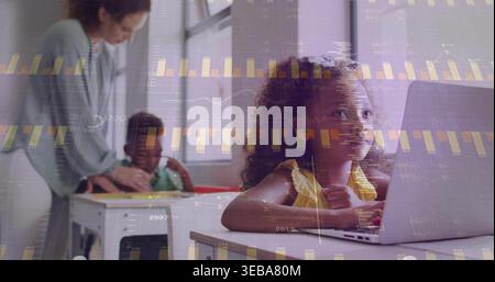 Working girl in yellow ruffled top typing on laptop at school desk, data overlay, copy space Stock Photo