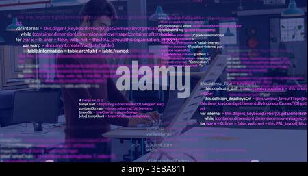 Typing two coworkers working apart at open office, wearing business-casual attire with code overlay Stock Photo