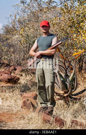 Hunting, gun and man on a Africa safari in the grass for shooting animals  on holiday. Weapon, sniper and male person aim for wild game in nature with  Stock Photo - Alamy
