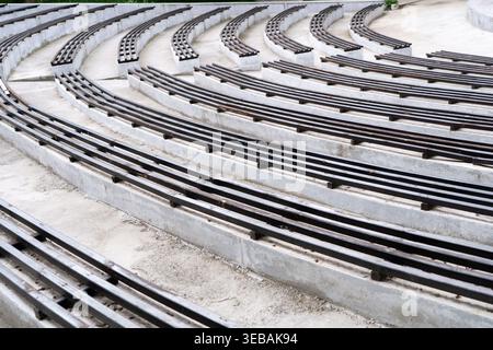 Empty concrete amphitheater stands with wooden benches arranged in repeating geometric rows. Concept: repeating objects Stock Photo