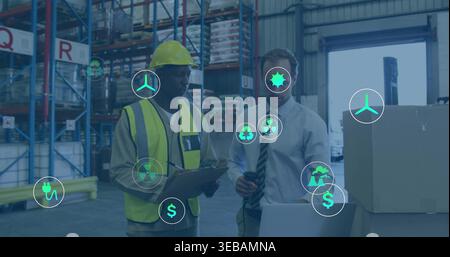 Reviewing stock in depot, worker in hat vest holding clipboard, manager in shirt tie using laptop Stock Photo