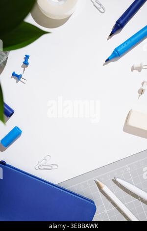 Stationery frame with pencils, markers, eraser, notebook on white background. Copyspace Stock Photo