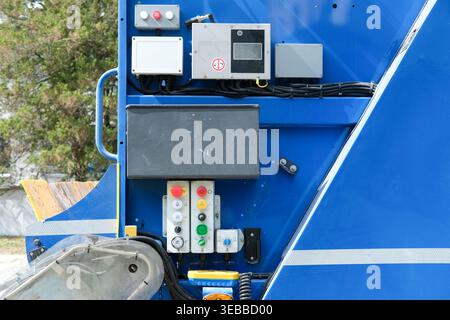 Industrial control panel with buttons and joystick is mounted on the side of a waste management vehicle Stock Photo