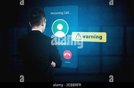 A man in a suit stands with his back turned, staring at a digital screen displaying an unknown incoming call, accompanied by a warning. Gantry Stock Photo