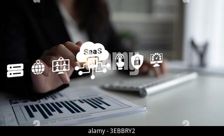 A business professional uses advanced SaaS and AI technologies to analyze data in a modern office, showcasing innovation and growth in digital Stock Photo
