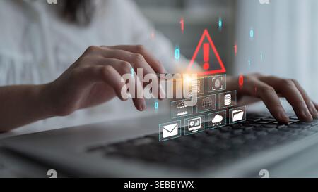 Hands Typing on Laptop with Digital Warning Sign and Icons Representing Technology, Security, Data, and Communication Quark. Stock Photo