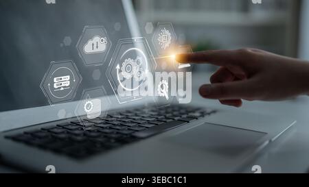 Hand Interacting with Futuristic Digital Interface on Laptop Display Featuring Icons of Technology, Data Analytics, and Cloud Computing Integration Stock Photo