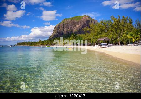 Tropical beach with boats, palm trees, and Le Morne Brabant mountain, Mauritius Stock Photo