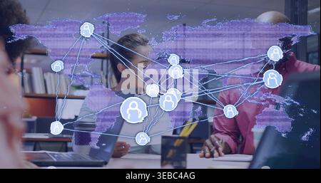 Discussing colleagues in light blazer and pink shirt using laptops at office with global map Stock Photo