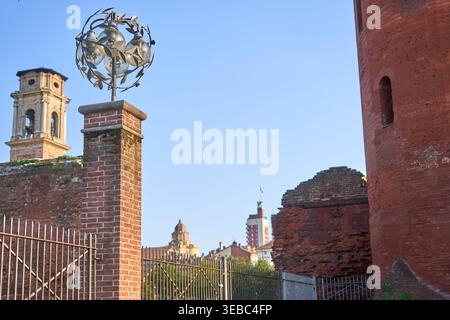 A view of historic architecture in Turin, Italy, featuring an ornate street lamp with multiple glass globes encased in a decorative wrought iron Stock Photo