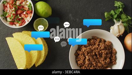 Showing bowl of seasoned beef sitting on dark slate with taco shells, chat overlays, copy space Stock Photo
