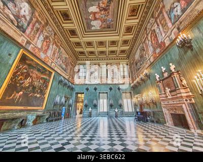 Grand ornate interior of a historic palace hall featuring a black and white checkerboard marble floor and lavish architectural details. The room Stock Photo