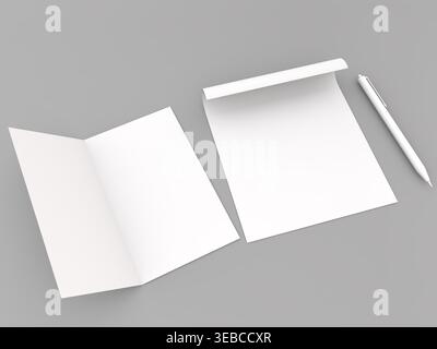 Two sheets of blank paper are displayed with a pen beside them on a grey surface. One sheet is folded while the other is flat and open inviting creati Stock Photo