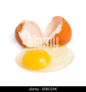 Raw chicken egg broken on a white surface with visible yolk and white. Fresh ingredient for baking and cooking. Stock Photo