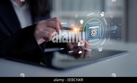 Business professional using digital tablet to interact with futuristic interface displaying technology icons and cybersecurity elements for modern Stock Photo